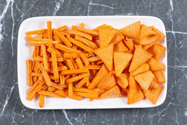 Surtido de chips con especias en un plato blanco.