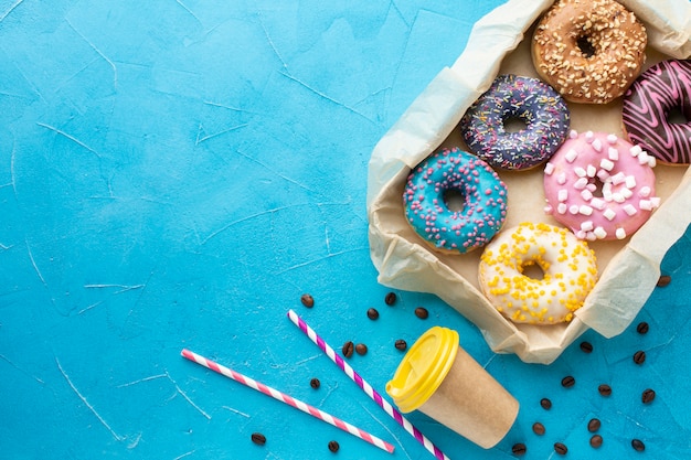 Surtido de donas y espacio de copia de taza