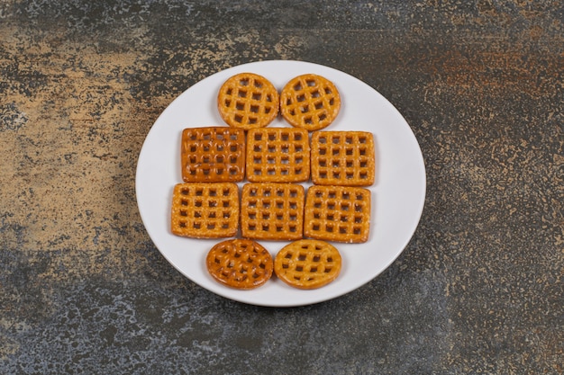 Foto gratuita surtido de galletas saladas en un plato blanco.