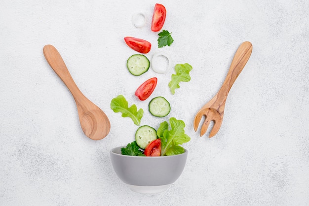 Surtido de ingredientes para ensalada sobre fondo blanco.