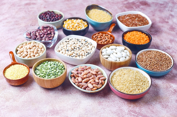 Foto gratuito surtido de legumbres y frijoles en diferentes cuencos sobre superficie de piedra clara. vista superior. alimentos proteicos veganos saludables.