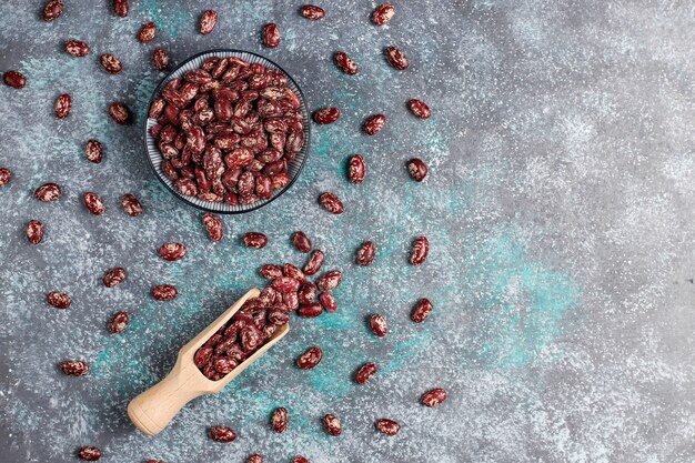 Surtido de legumbres y frijoles en diferentes tazones sobre superficie de piedra clara. Vista superior. Comida sana de proteínas veganas.