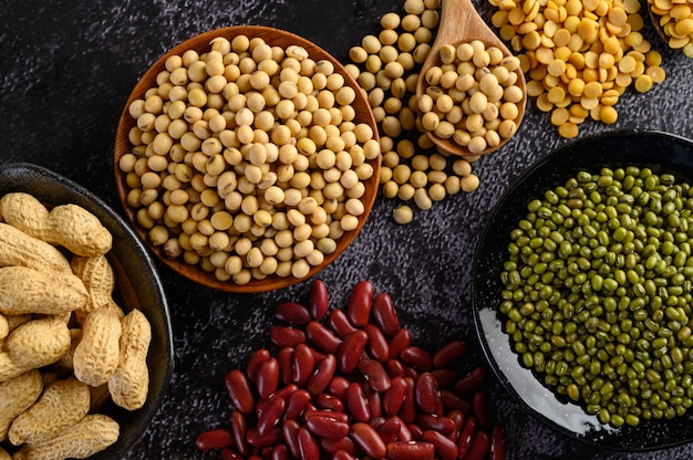 Surtido de legumbres y frijoles en el piso de cemento negro.