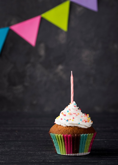 Surtido con muffins y velas sobre fondo de madera