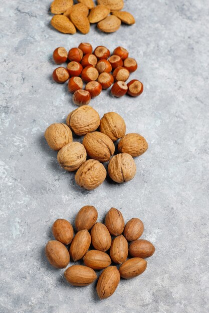 Surtido de nueces sobre superficie de concreto. Avellanas, nueces, nueces, maní, almendras, vista superior