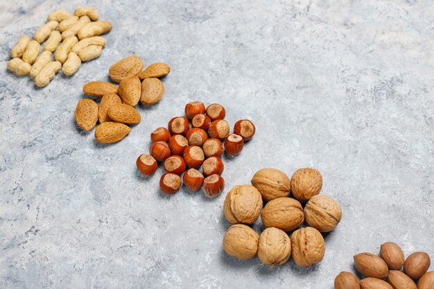 Surtido de nueces sobre superficie de concreto. Avellanas, nueces, nueces, maní, almendras, vista superior