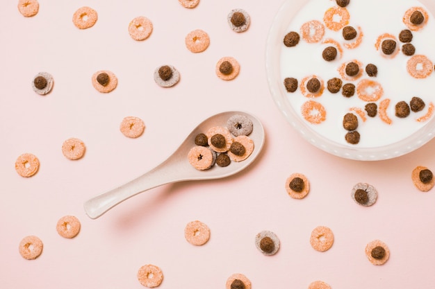 Foto gratuita surtido plano con cereales coloridos y tazón de leche