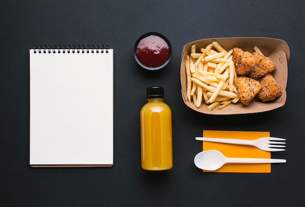 Foto gratuita surtido plano con papas fritas y cuaderno