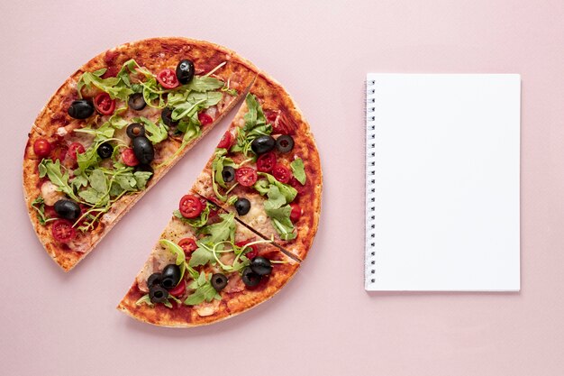 Surtido plano con pizza y cuaderno