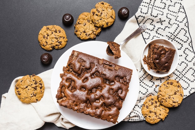 Surtido plano con tarta de chocolate y galletas.