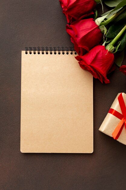 Surtido de San Valentín con rosas y primer plano libreta vacía