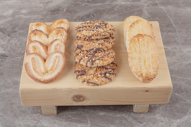 Surtido de snacks con diferentes galletas en una pequeña tabla de mármol