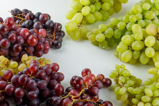 Surtido de uvas en blanco, vista de ángulo alto.