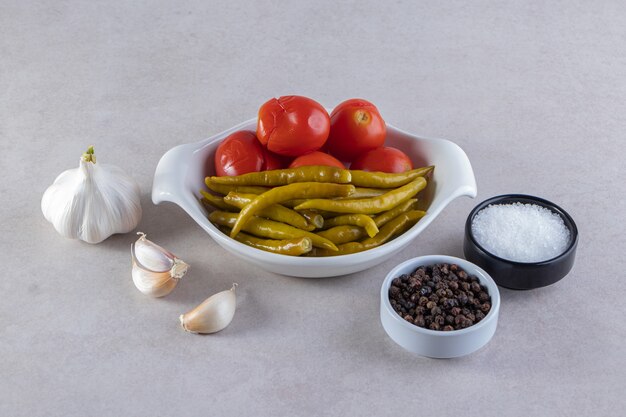 Surtido de verduras encurtidas colocadas sobre una superficie de piedra.