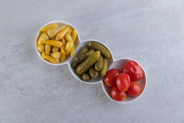 Surtido de verduras encurtidas colocadas sobre una superficie de piedra.