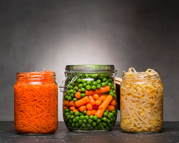 Foto gratuita surtido de verduras en escabeche en frascos de vidrio