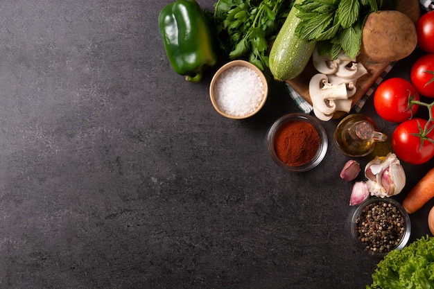 Surtido de verduras hierbas y especias sobre fondo negro Vista superior Espacio de copia