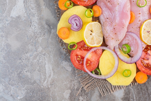 Surtido de verduras y pechuga de pollo, sobre el fondo de mármol.