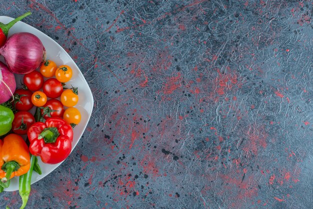 Foto gratuita surtido de verduras en un plato, sobre el fondo de mármol.