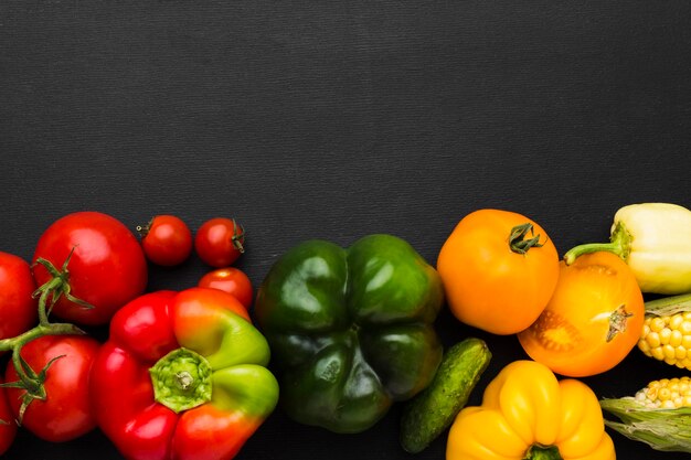 Surtido de verduras sobre fondo oscuro con espacio de copia