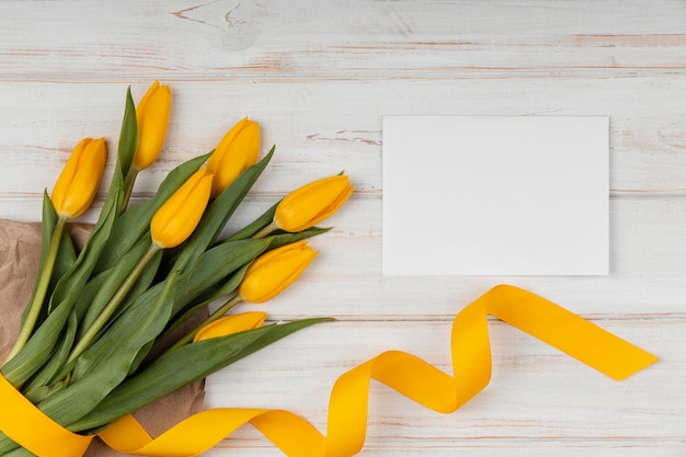 Surtido de vista superior de tulipanes amarillos con tarjeta vacía