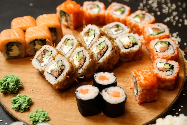 Sushi con atún, salmón, verduras, jengibre, wasabi, vista lateral