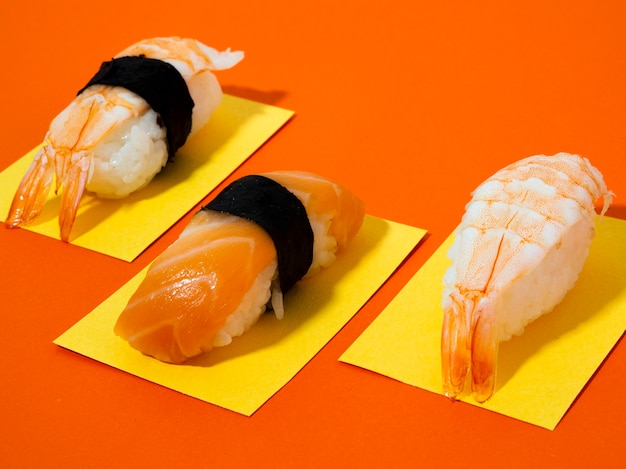 Sushi de camarones y salmón sobre fondo naranja