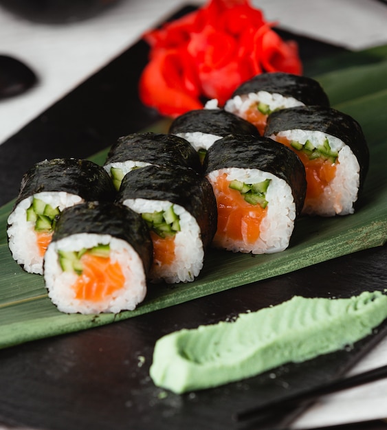 Sushi nori con salmón y aperitivos alrededor.