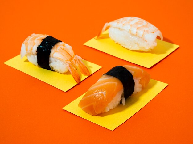 Foto gratuita sushi de salmón y camarones sobre fondo naranja