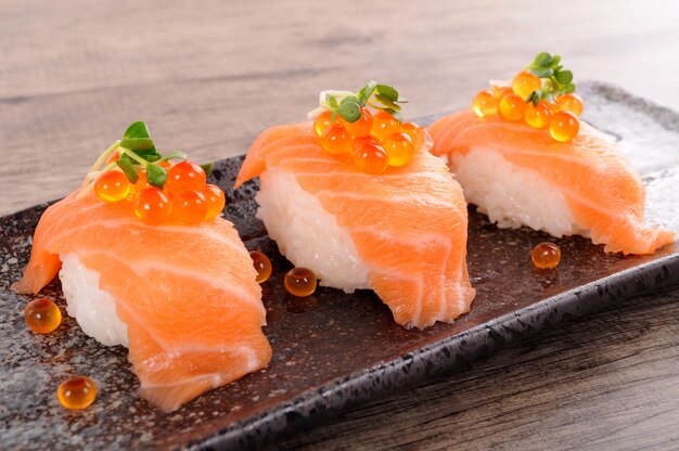 Sushi de salmón con caviar en plato negro