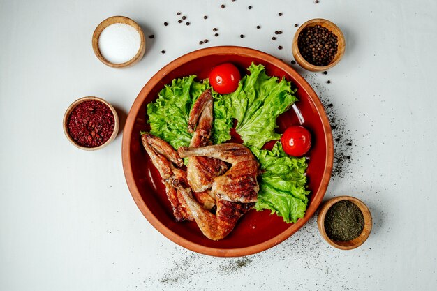 Tabaco de pollo frito sobre lechuga y tomate