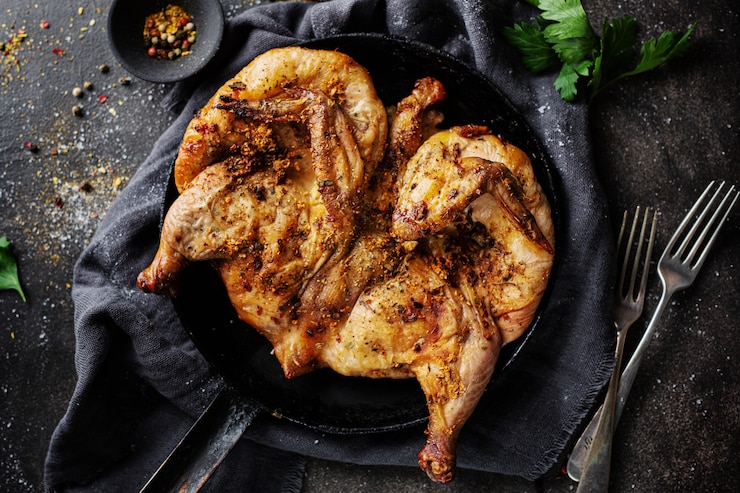 Foto gratuito tabaka de pollo al horno con especias