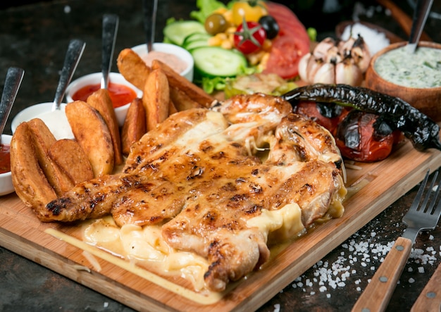 Tabaka de pollo frito en el horno sobre tabla de madera