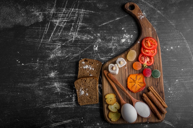 Tabla de aperitivos con patatas fritas, tomates y bollería