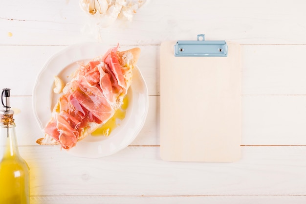 Tabla de cocina con sándwich y portapapeles