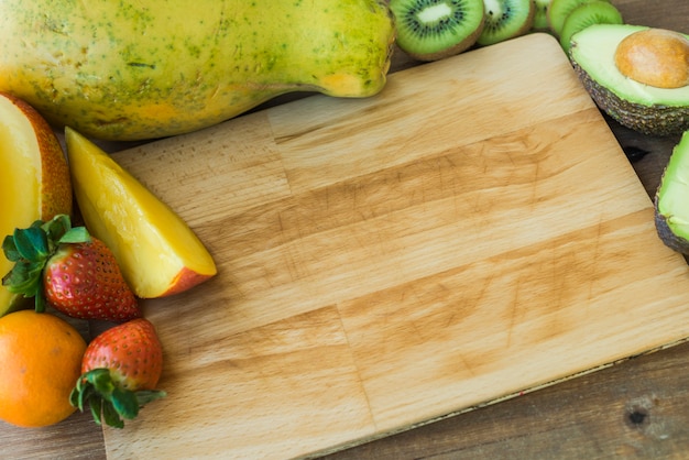 Tabla de cortar con fruta alrededor