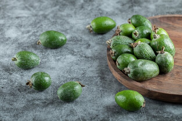 Una tabla de cortar de madera con feijoa fresca.