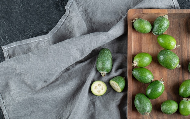 Una tabla de cortar de madera con feijoa fresca.