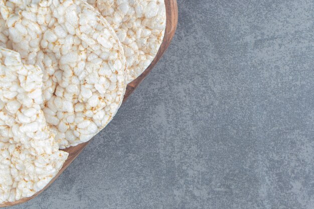 Una tabla de cortar de madera con pan de arroz inflado.