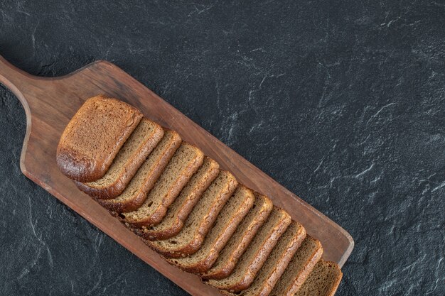 Una tabla de cortar de madera con rebanadas de pan.