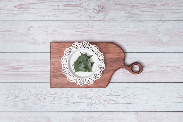 Tabla de cortar con placa de adorno y hojas verdes