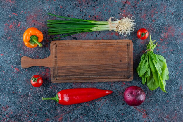 Tabla de cortar y verduras, sobre el fondo de mármol.