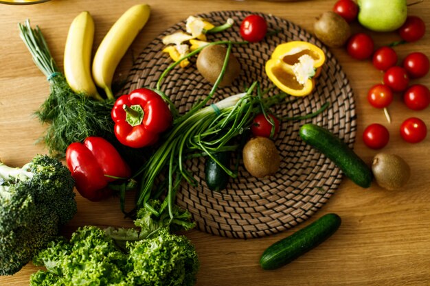 Tabla flatlay con frutas y verduras frescas, pimientos, cebolla, cucubmers, tomates, vibraciones saludables.