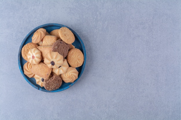 Una tabla de madera azul con dulces deliciosas galletas redondas de cilicio.