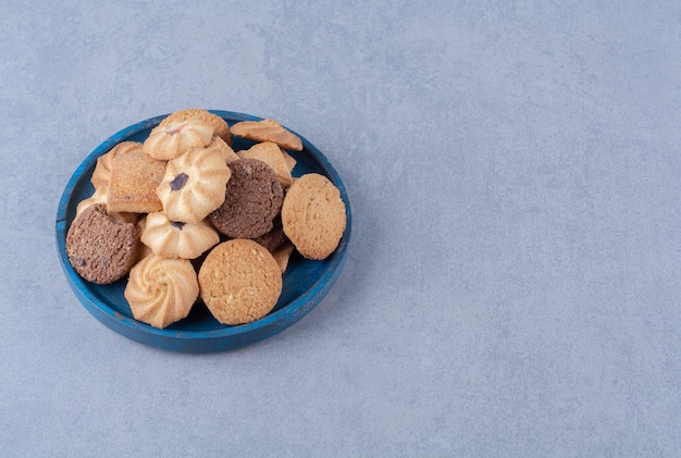 Una tabla de madera azul con dulces deliciosas galletas redondas de cilicio.