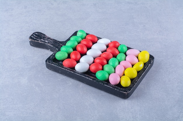 Una tabla de madera de coloridos caramelos dulces de gominolas. Foto de alta calidad