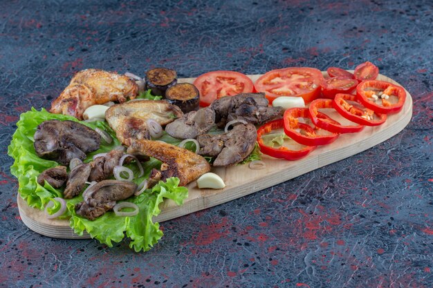 Una tabla de madera con comida deliciosa en la superficie de mármol.