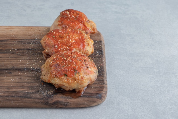 Una tabla de madera con deliciosa carne de pollo frita.