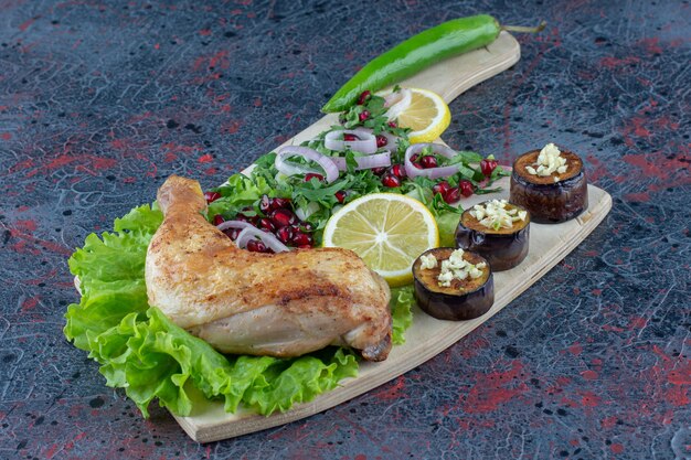Una tabla de madera con deliciosa comida en la superficie de mármol.