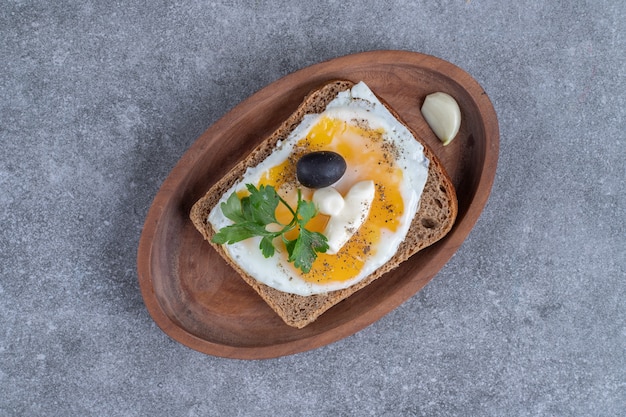 Una tabla de madera de deliciosas tostadas con huevo cocido. Foto de alta calidad